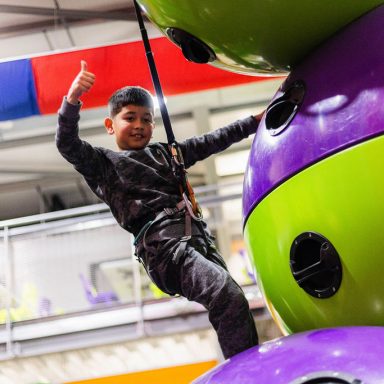 Young boy giving thumbs up on Astroball Climb and Climb challenge at High Rise Lisburn