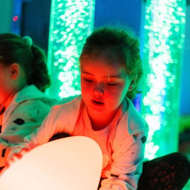 Young girl playing with the sensory egg light in the sensory rooms at High Rise Lisburn